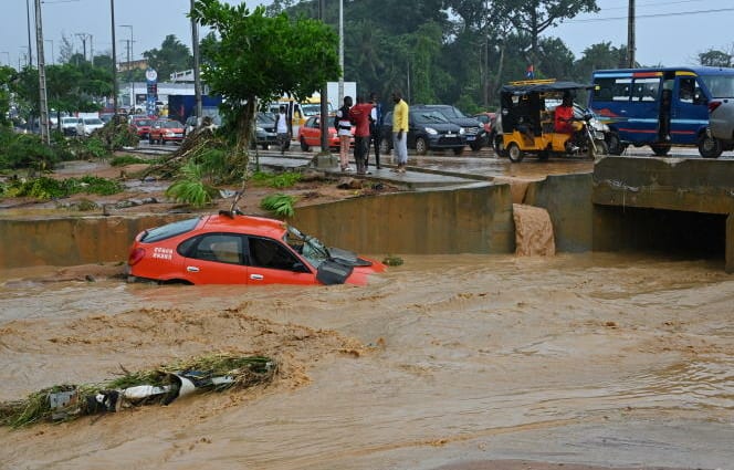 A taxi is swept away by torrential rain in Bingerville near Abidjan on June 21, 2022. (Photo by Issouf SANOGO / AFP)