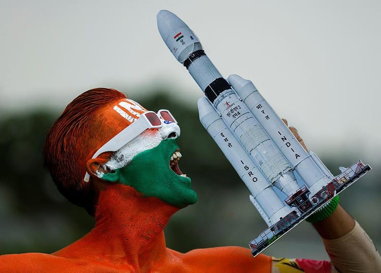 Arun Haryani, un passionné dont le corps est peint en tricolore, réagit le 22 août 2023 en brandissant un modèle de LVM3 M4 qui a été utilisé pour le lancement du vaisseau spatial Chandrayaan-3 à la veille de son atterrissage sur la lune. | Crédit photo : Reuters