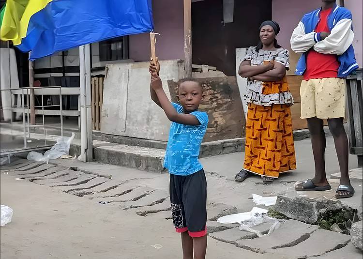 Un enfant portant un drapeau du Gabon dans les rues