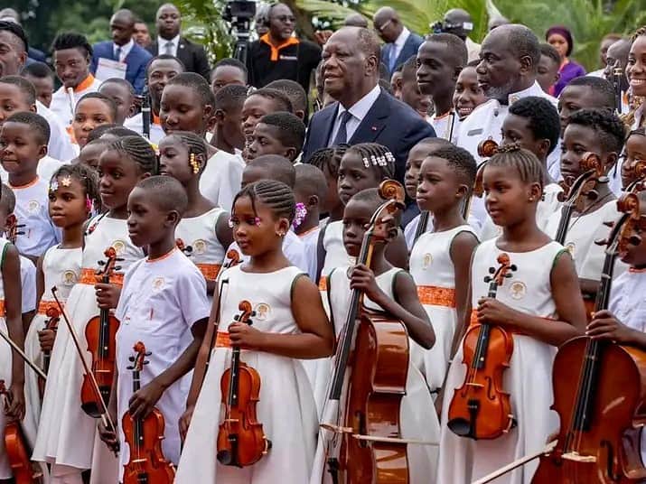 Le Chef de l’Etat Alassane Ouattara au milieu des enfants de l’orchestre philarmonique d’Odienné (DR)