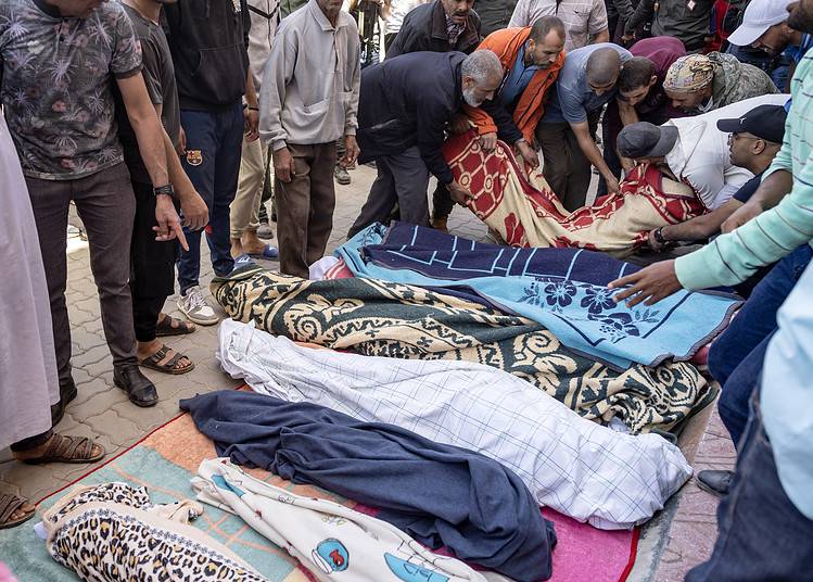 Des hommes alignent les corps des personnes tuées lors d'un tremblement de terre à Moulay Brahim, dans la province d'Al Haouz, le 9 septembre 2023. 
 (Photo par FADEL SENNA / AFP)